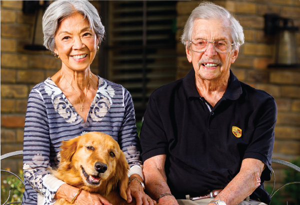 Colette Dishman smiling with husband and their golden retreiver